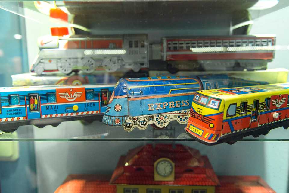 Tin trains from Turkey sitting next to the display room set up like a train compartment by set designer Ayhan Dogan.