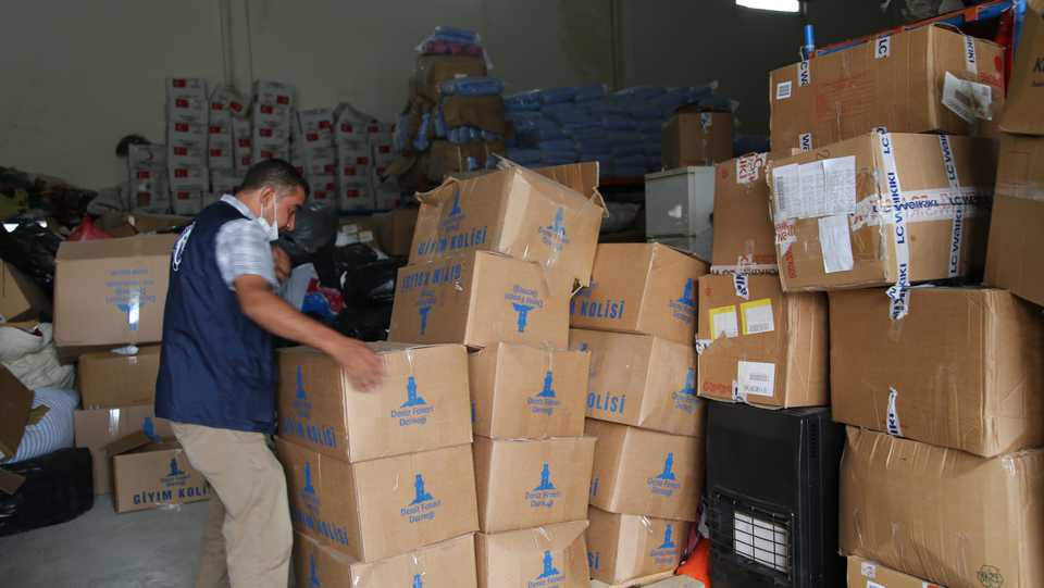Turkish volunteers transfer boxes of humanitarian aid into the trucks to be sent to Syria in Sanliurfa, Turkey on July 8, 2020.
