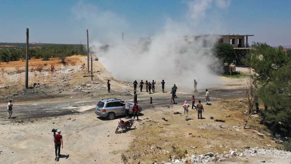 An aerial picture shows Syrians gathering at the site of an improvised explosive device which hit a joint Turkish-Russian patrol near the Syrian town of Ariha in opposition-held northwestern Idlib province on July 14, 2020.