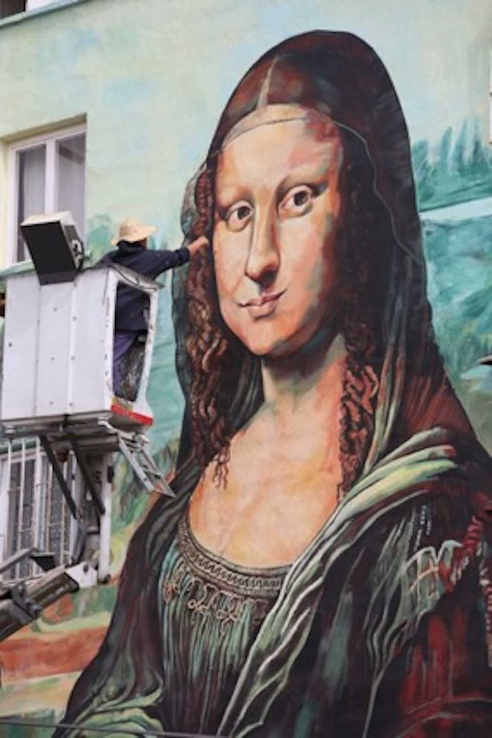 Nazife Bilgin Hazar painting an oversize version of Leonardo da Vinci’s Mona Lisa.