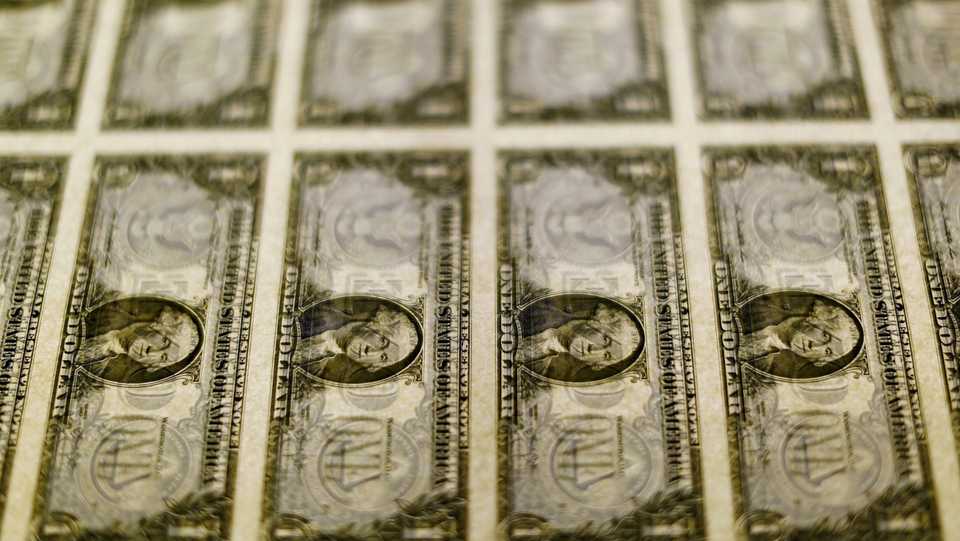 United States one dollar bills are seen on a light table at the Bureau of Engraving and Printing in Washington, November 14, 2014.