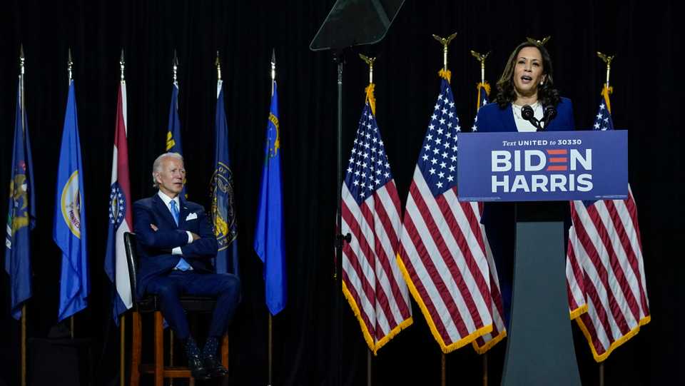 Democratic presidential candidate former Vice President Joe Biden (L) looks on as his running mate California Senator Kamala Harris speaks during an event at the Alexis Dupont High School on August 12, 2020 in Wilmington, Delaware.