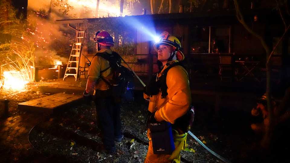 Firefighter monitor the advance of the CZU August Lightning Complex Fire in the backyard of a home on August 21, 2020, in Boulder Creek, Calif.