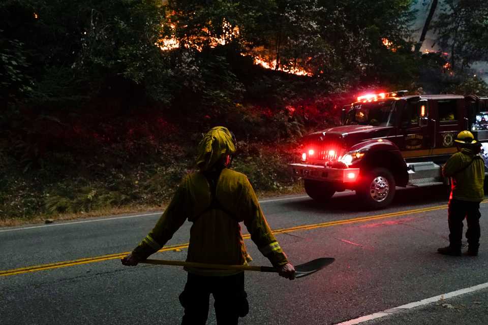 Crews from the Boulder Creek Fire Department keep an eye out on a flare up from the CZU August Lightning Complex Fire along Highway 9, Saturday, August 22, 2020, in Boulder Creek, California.