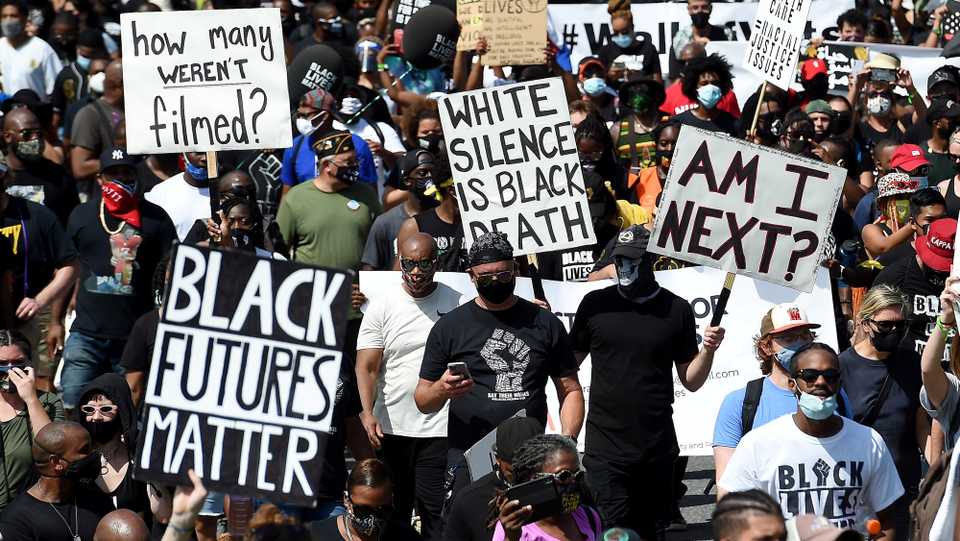 People holding placards attend the 'Get Your Knee Off Our Necks' march in support of racial justice, in Washington, US, August 28, 2020.