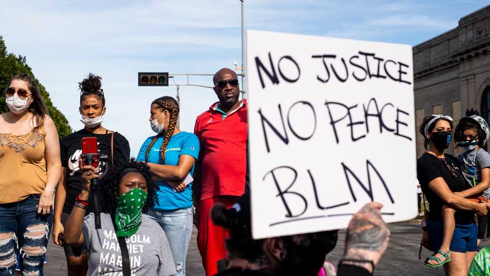 Demonstrators look on as speakers talk about the shooting of Jacob Blake during a rally against racism and police brutality in Kenosha, Wisconsin, on August 29, 2020.