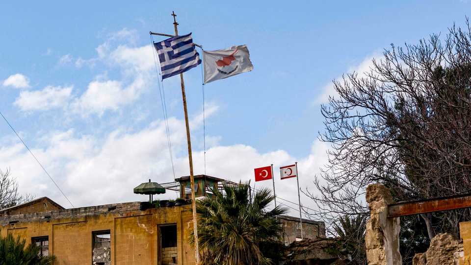 A view of (L to R, foreground) the flags of Greece, Greek-administered Cyprus, (L to R, background) Turkey and the Turkish Republic of Northern Cyprus (TRNC) flying on respective security outposts lying off both sides of the United Nations Buffer Zone in the old walled city of the divided capital Nicosia. February 7, 2020.