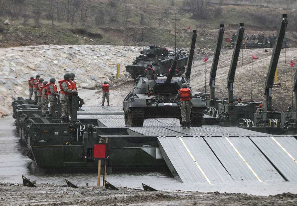 Wheeled military vehicles and tanks cross over the Mobile Amphibious Assault Bridge (SAMUR), floating bridges and fixed bridges during 'Transition From Stagnant Water' military drill conducted by Koprucu Battalion of Kirklareli 55th Mechanized Infantry Brigade Command with the participation of 197 military personnel and 61 armoured military vehicles at Major General Muhittin Onur pond in Kirklareli, Turkey on February 15, 2018.