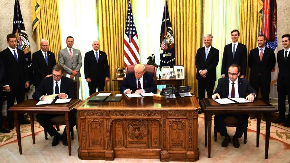 US President Donald Trump signs a document as Kosovar Prime Minister Avdullah Hoti (R) and Serbian President Aleksandar Vucic (L) sign an agreement, in the Oval Office of the White House in Washington, DC, on September 4, 2020.