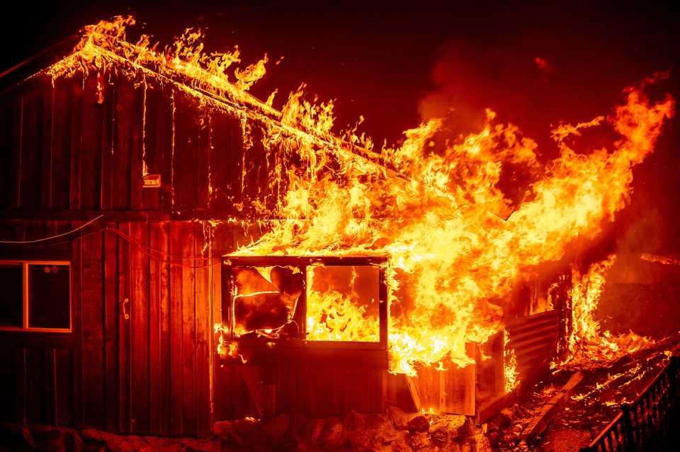 Flames shoot from home as the Bear Fire burns through the Berry Creek area of Butte County, California.
