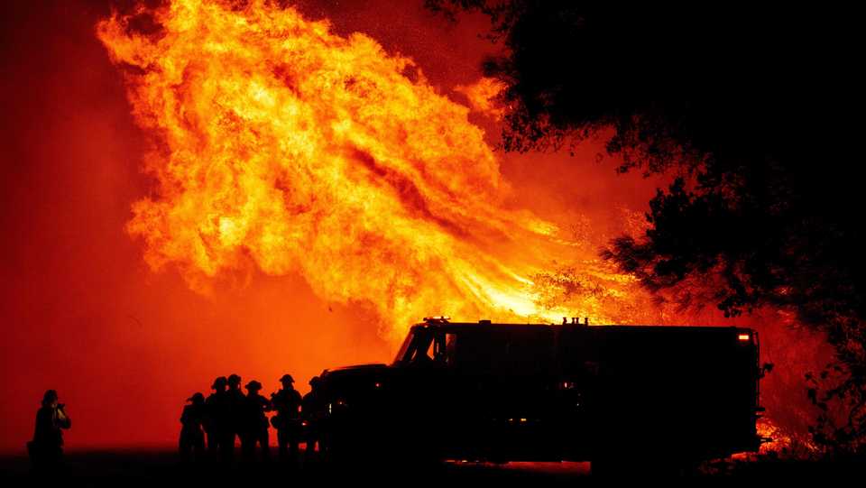 Butte county firefighters watch as flames tower over their truck during the Bear fire in Oroville, California on September 9, 2020.
