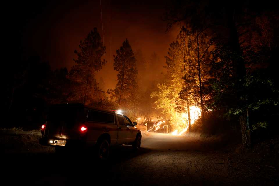 A Cal Fire vehicle drives through burning vegetation near Lake Oroville as wildfires rage across California, US on September 9, 2020.