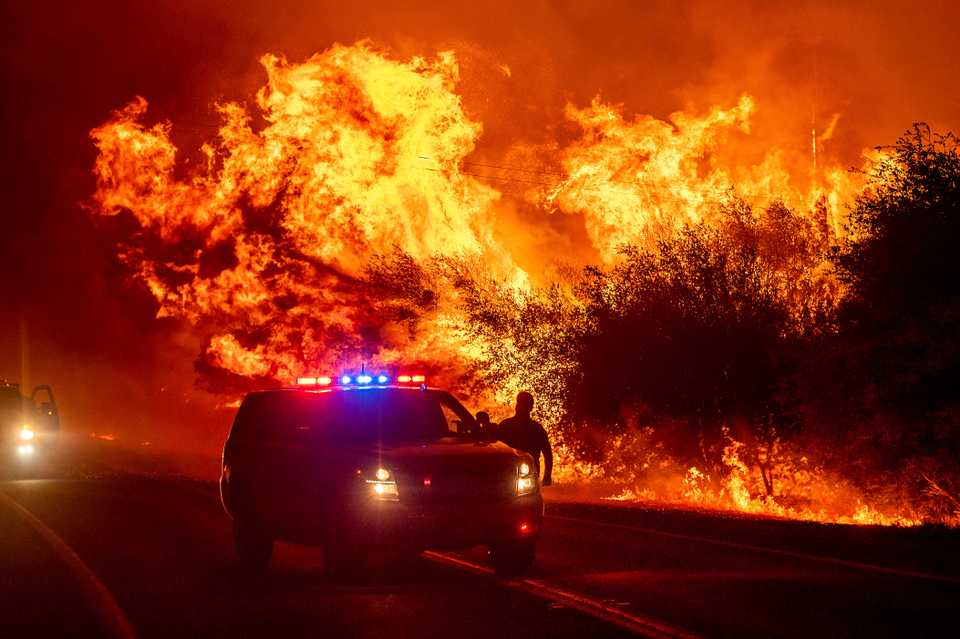 Flames lick above vehicles on Highway 162 as the Bear Fire burns in Oroville, California, September 9, 2020.