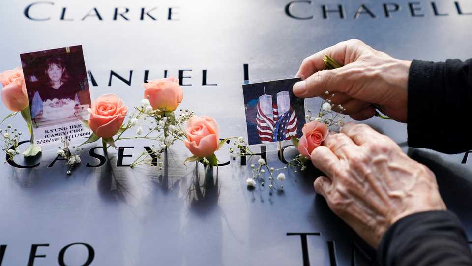 Mourners place flowers and pictures at the National September 11 Memorial and Museum in New York. September 11, 2020.