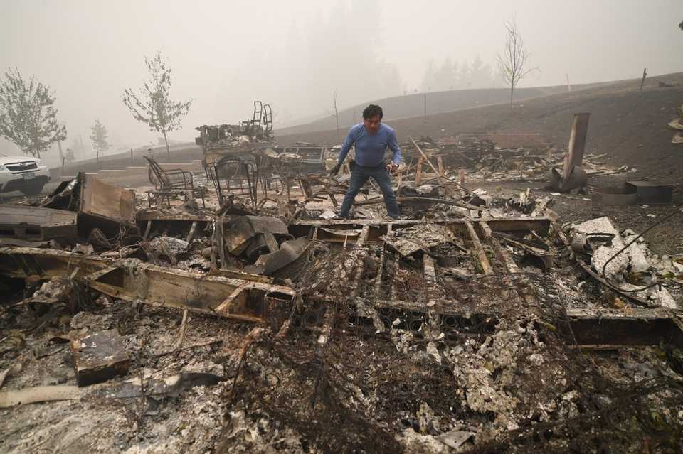 Marcelino Maceda looks for items in the remains of his mobile home after a wildfire sweep through the RV park destroying multiple homes in Estacada, Oregon, September 12, 2020.