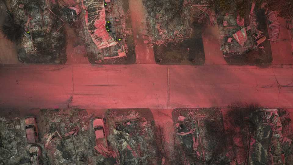 A search and rescue team, surrounded by red fire retardant, look for victims under burned residences and vehicles in the aftermath of the Almeda fire in Talent, Oregon, US, September 13, 2020.