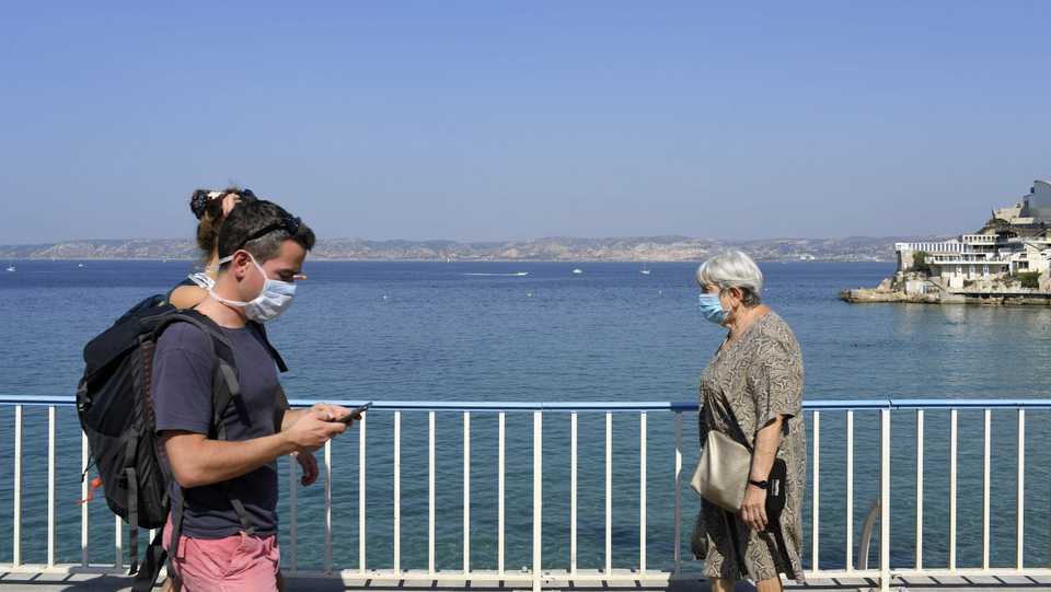 Pedestrians wearing face masks walk on the Corniche seafront in Marseille, southeastern France, on September 14, 2020.