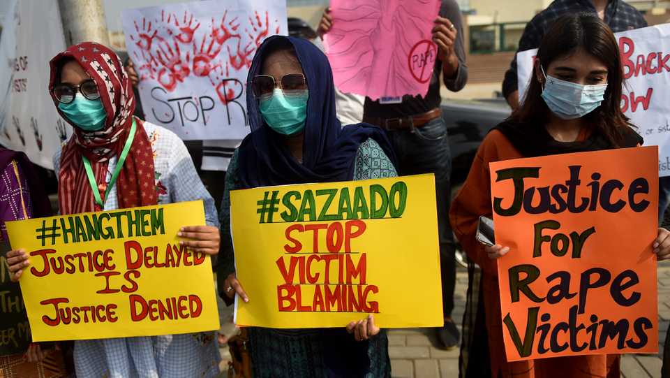 Members of VCare Welfare Trust hold placards during a protest against an alleged gang rape of a woman, in Karachi on September 13, 2020.