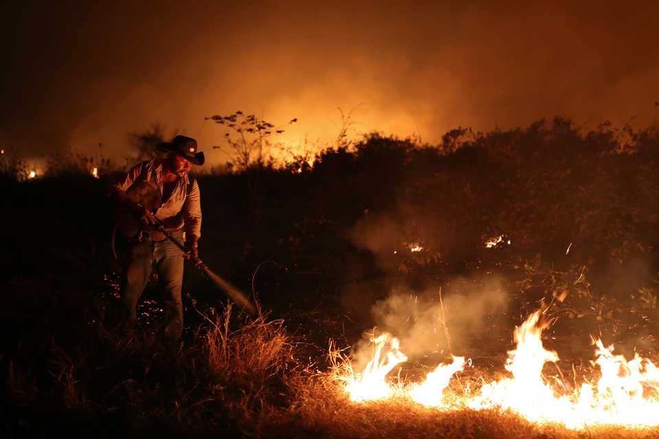 Sebastiao Baldi Silva Junior, 40, who works on a farm, attempts to put out a fire on a ranch in the Pantanal, the world's largest wetland, in Pocone, Mato Grosso state, Brazil, August 26, 2020.
