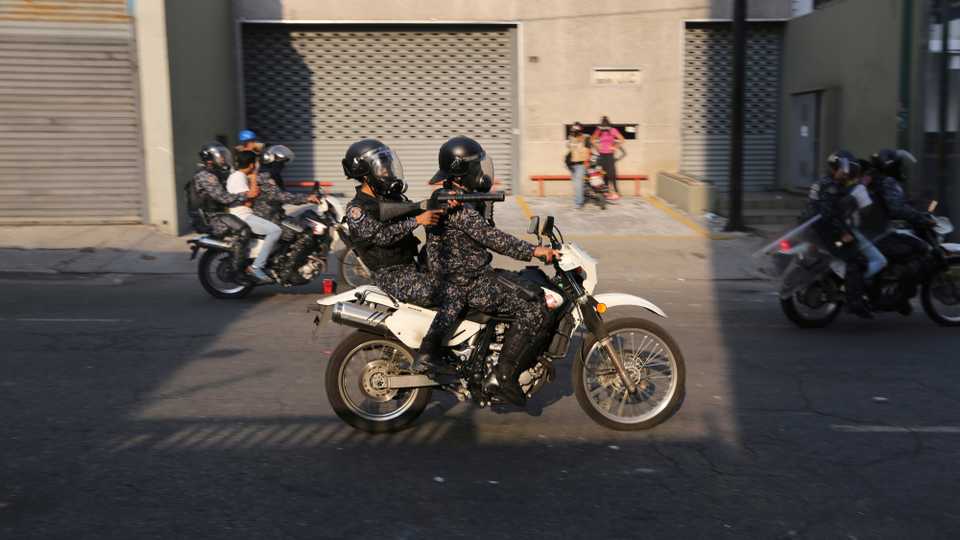 Detained anti-government protesters are driven away by National Police on motorcycles during clashes between protesters and security forces, in Caracas, Venezuela, May 1, 2019.