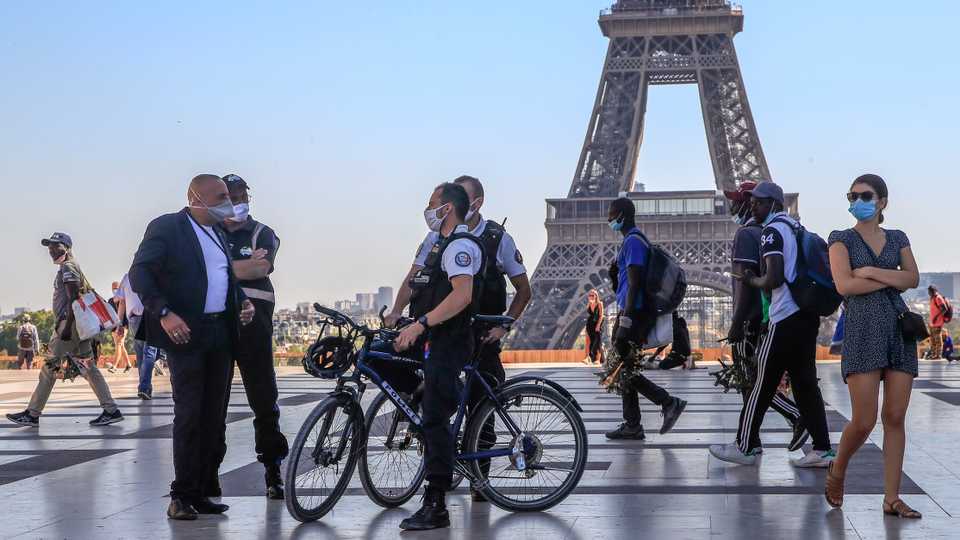 Police officers talk to a man while wearing protective face masks as precaution against the conoravirus at Tocadero plaza near the Eiffel Tower in Paris, France, September 14, 2020.