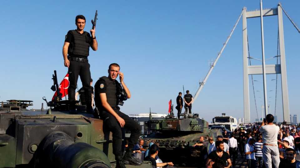 Policemen stand atop military armored vehicles after troops involved in the failed coup surrendered on the Bosphorus Bridge in Istanbul, Turkey, July 16, 2016.