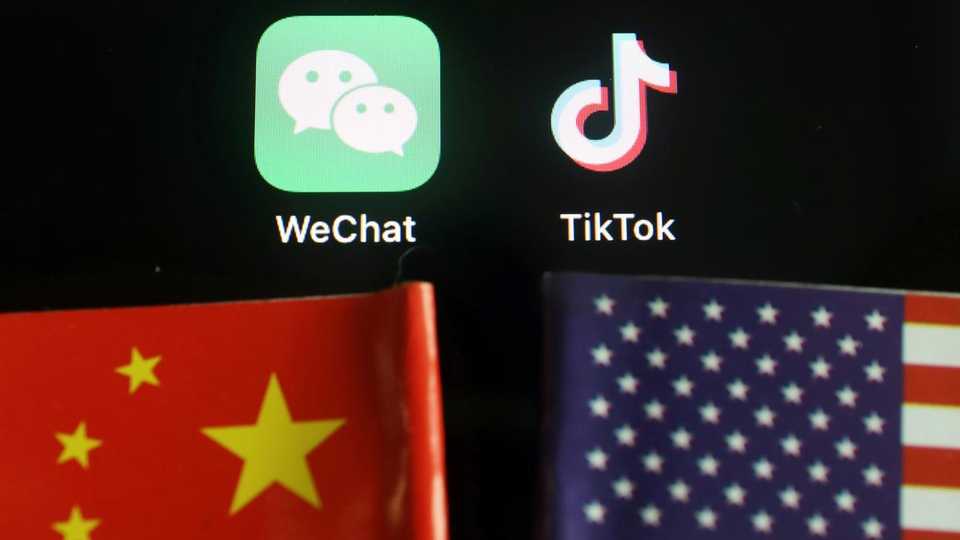 The messenger app WeChat and short-video app TikTok are seen near China and US flags in this illustration picture taken on August 7, 2020.