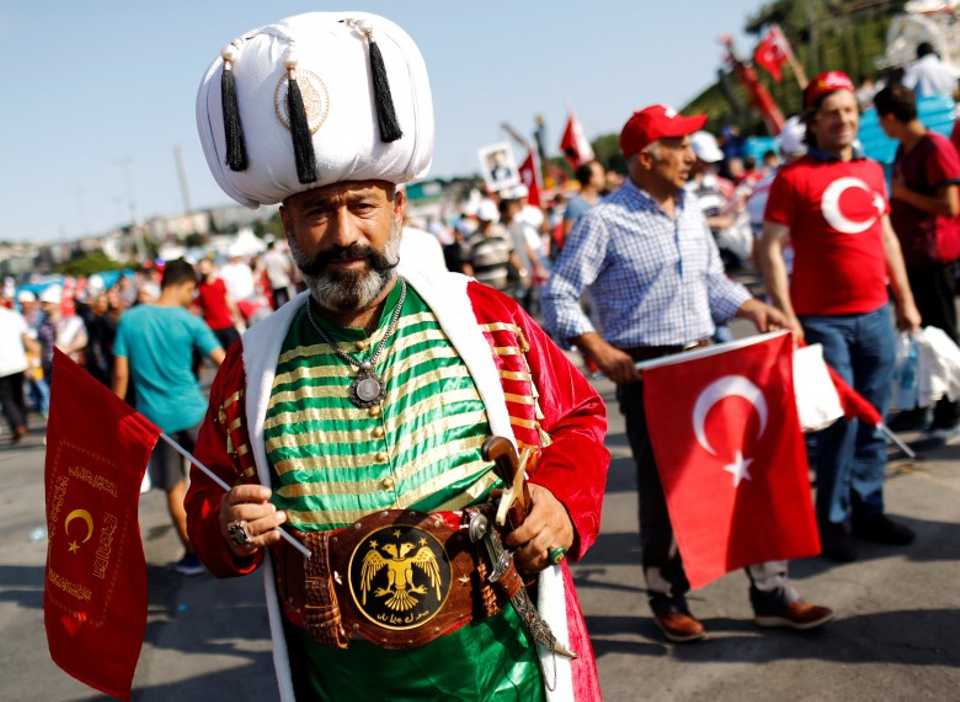 A man in historical Ottoman clothing poses as he attends the ceremony which takes place at the July 15 Martyrs Bridge 
 in Istanbul,Turkey