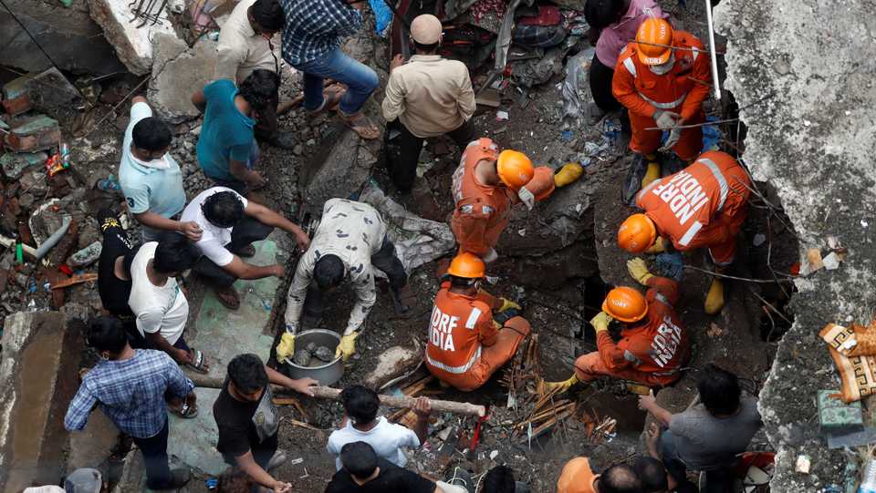 India's National Disaster Response Force officials search for survivors as people help clear the rubble after a three-storey building collapsed in Bhiwandi, on the outskirts of Mumbai, India. September, 21 2020.