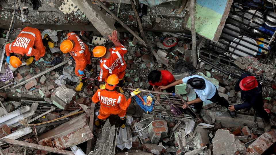 National Disaster Response Force officials and firemen remove debris as they look for survivors after a three-storey residential building collapsed in Bhiwandi on the outskirts of Mumbai, India on September 21, 2020.