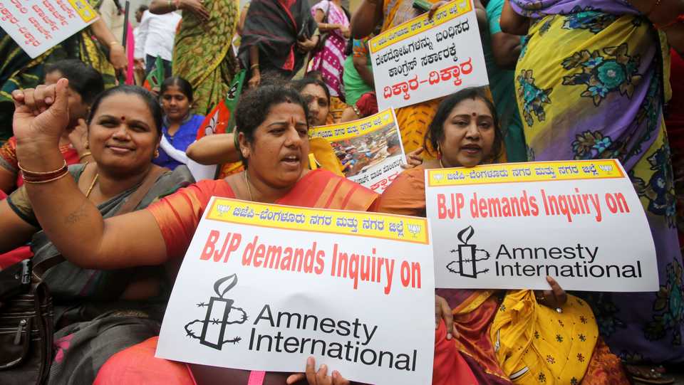 In this August 24, 2016 file photo, members and activists of India's governing Bharatiya Janata Party (BJP) protests against Amnesty International in Bangalore, India. A sedition case was registered against the rights group in Bangalore for hosting a Kashmir event.