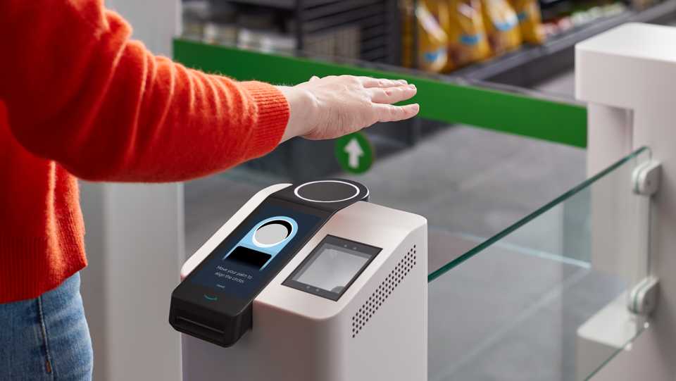This undated handout photo courtesy of Amazon shows a person waving their hand above the new Amazon palm recognition payment system called 