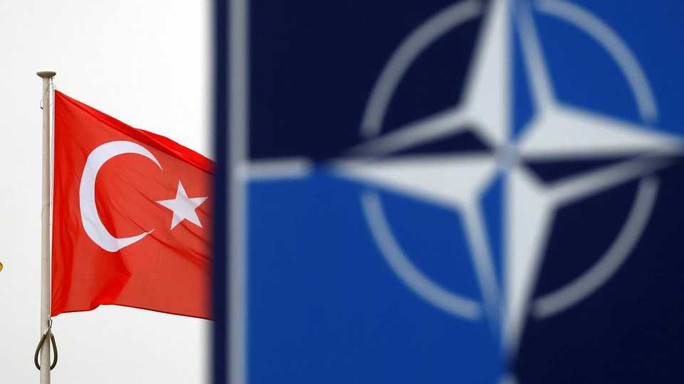 A Turkish flag flies next to NATO logo at the Alliance headquarters in Brussels, Belgium, November 26, 2019.