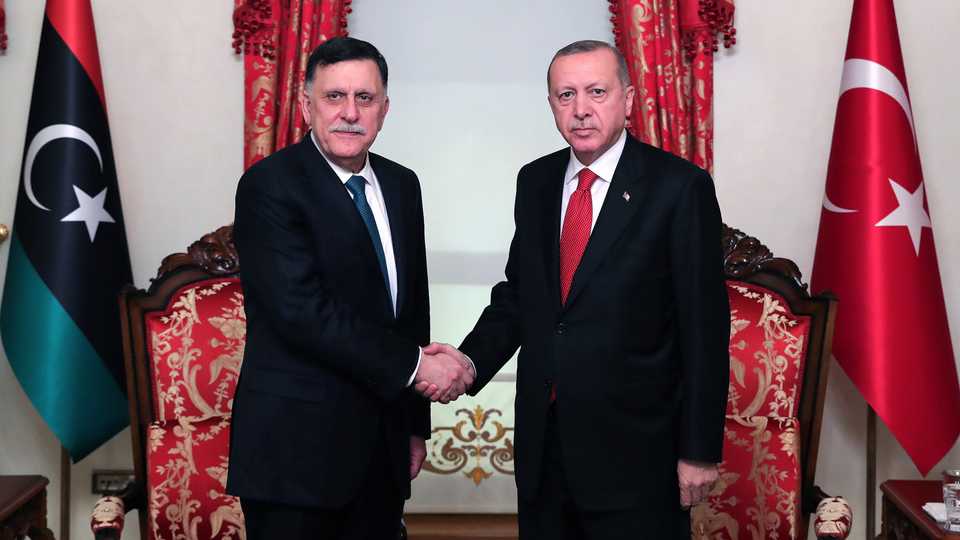 Turkish President Recep Tayyip Erdogan (R) shakes hands with Fayez al Sarraj, the Prime Minister of Libya's UN-recognised government, during their meeting in Istanbul on November 27, 2019.