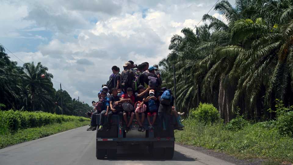 Honduran migrants, part of a caravan heading to the US, are seen aboard a truck in Entre Rios, Guatemala, after crossing the border from Honduras, October 1, 2020.