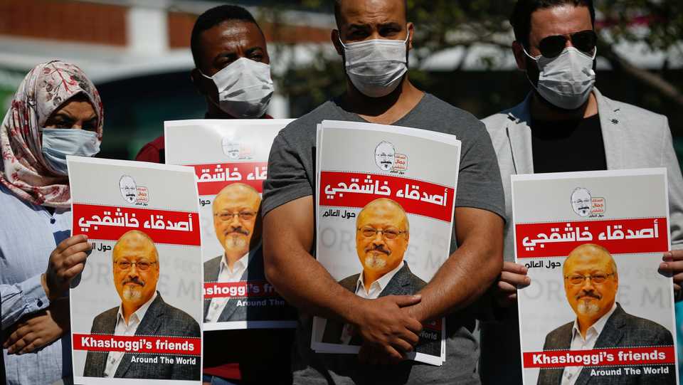 People hold posters of slain Saudi journalist Jamal Khashoggi, near the Saudi Arabia consulate in Istanbul, marking the two-year anniversary of his death, October 2, 2020.