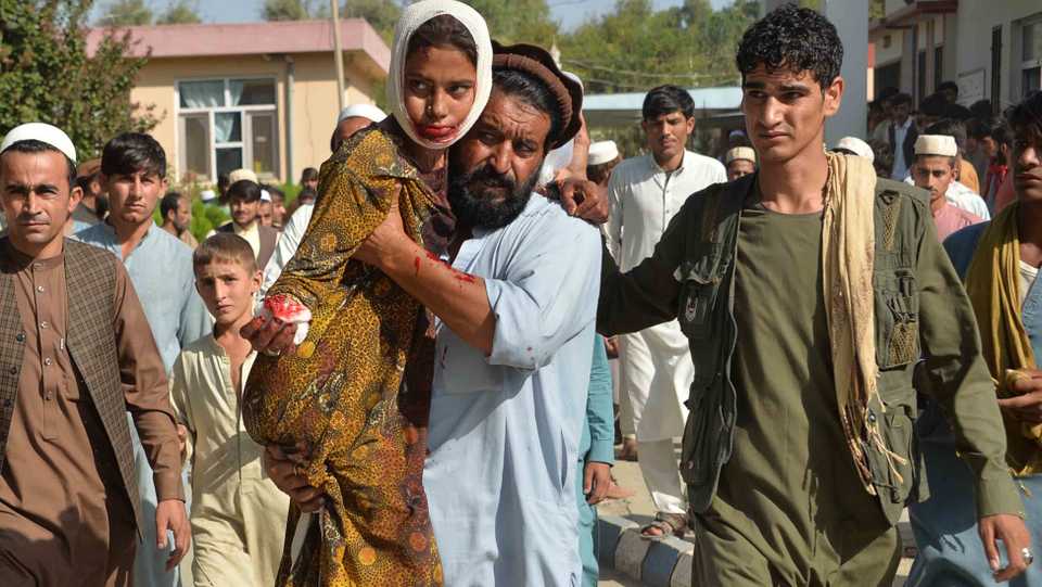 An injured youth is carried to a hospital following the attack that targeted a government building in the restive province, officials say.