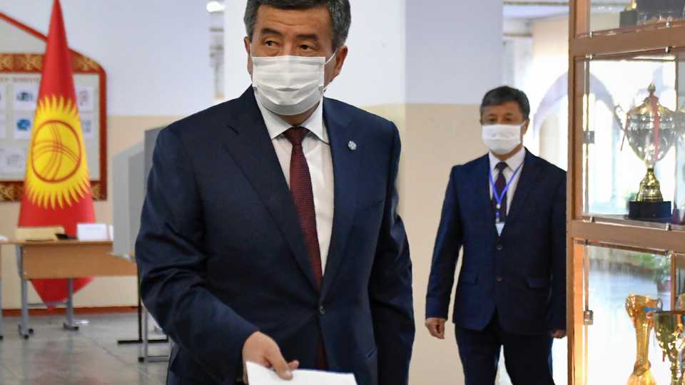 Kyrgyz President Sooronbay Jeenbekov wearing a face mask casts his ballot at a polling station during parliamentary election in Bishkek on October 4, 2020, amid the ongoing coronavirus pandemic.