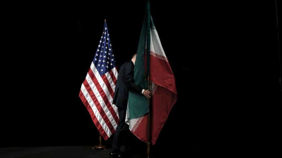 FILE PHOTO: A staff member removes the Iranian flag from the stage after the Iran nuclear talks at the Vienna International Center in Vienna, Austria, July 14, 2015.
