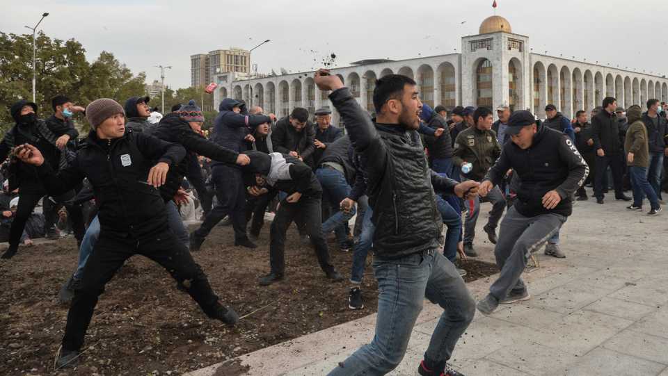 Supporters of nationalist Sadyr Japarov, who has styled himself as prime minister, throw clumps of earth towards supporters of former Kyrgyzstan's President Almazbek Atambayev as they attend a rally in Bishkek, Kyrgyzstan, on October 9, 2020.