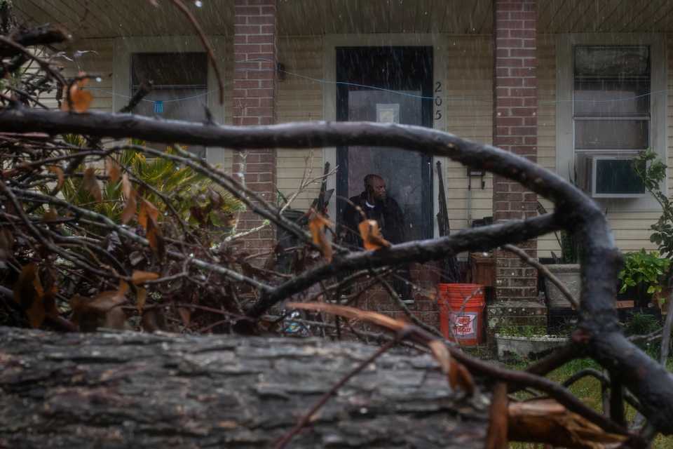 Michael Roberson, 46, is framed by debris from Hurricane Laura, as he watches the arrival of Hurricane Delta from his doorsteps in Lake Charles, Louisiana, US, October 9, 2020.