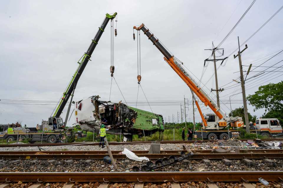 The wreckage of an overturned bus involved in a deadly collision with a train is lifted off the tracks next to Khlong Kwaeng Klan railway station in Chachoengsao province, Thailand, October 11, 2020.