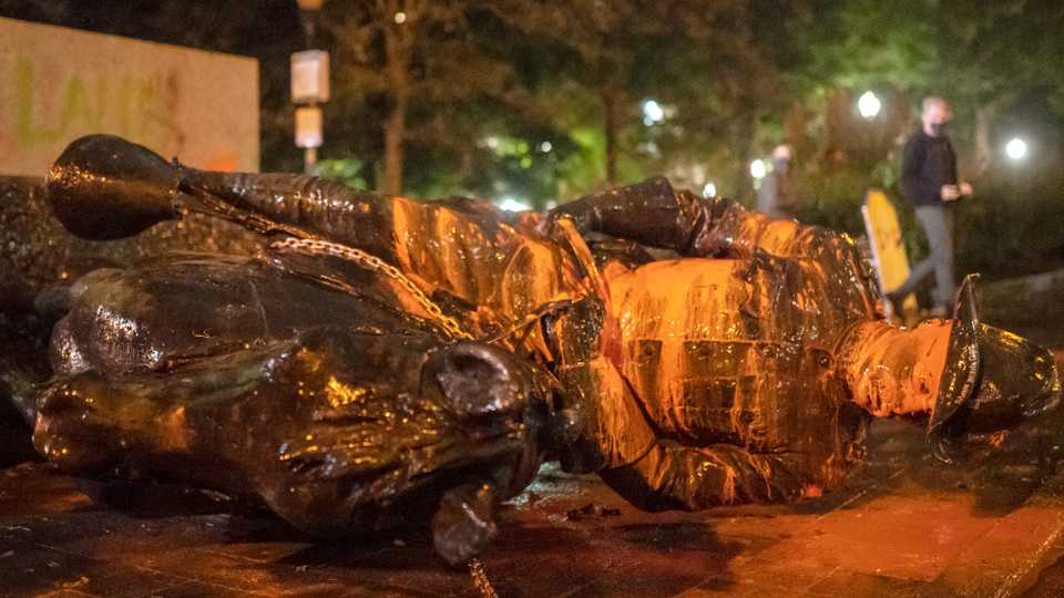 Protesters walk past a toppled statue of Theodore Roosevelt during an Indigenous Peoples Day of Rage protest on October 11, 2020 in Portland, Oregon.