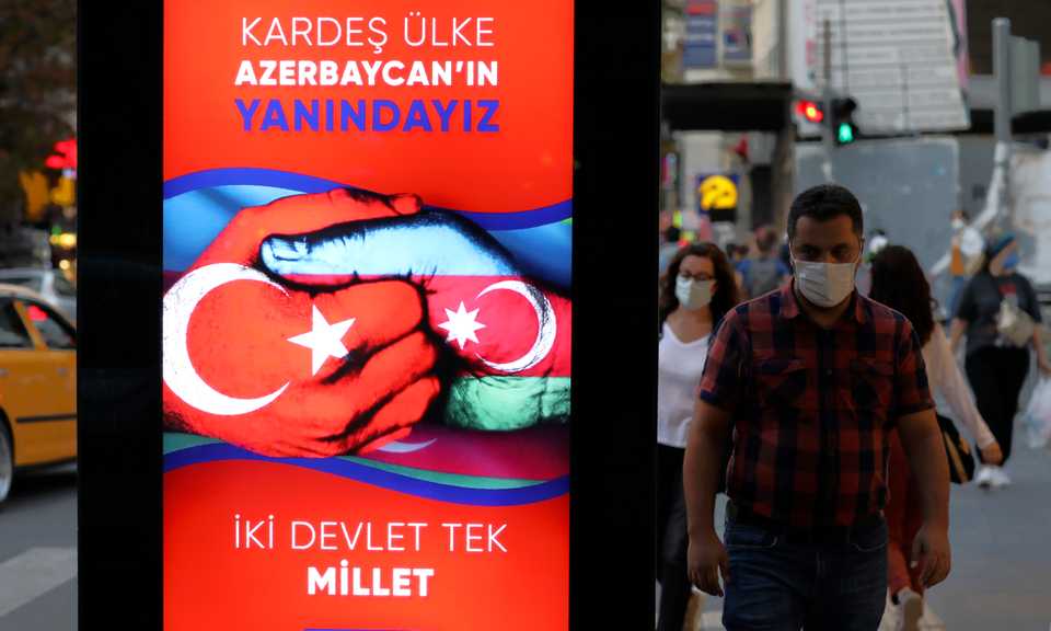 People walk past a billboard in support of Azerbaijan in its war with Armenia over the occupied Karabakh, in Ankara, Turkey. October 12, 2020.