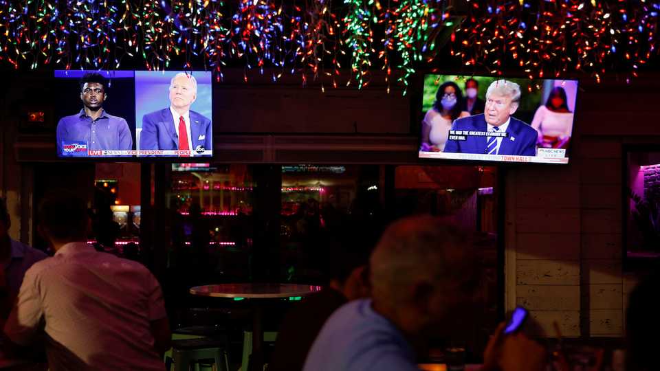 The dual town halls of US Democratic presidential candidate Joe Biden and US President Donald Trump are seen on television monitors at Luv Child restaurant ahead of the election in Tampa, Florida, US, October 15, 2020.
