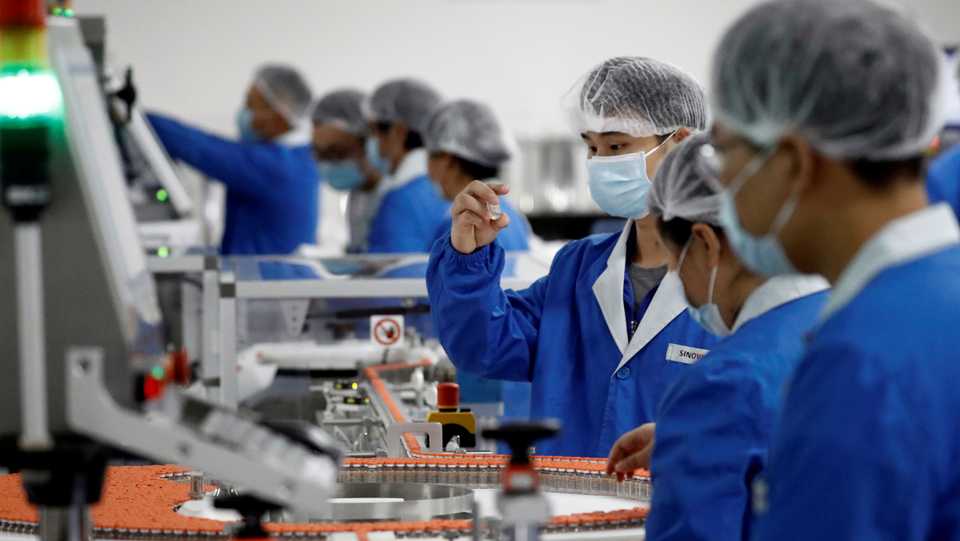 People work in the packaging facility of Chinese vaccine maker Sinovac Biotech, developing an experimental coronavirus disease vaccine, during a government-organized media tour in Beijing, China, file photo released October 16, 2020.