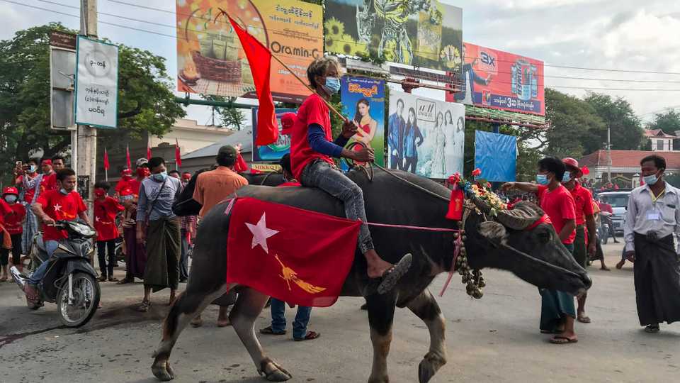 A supporter of the ruling National League for Democracy (NLD) party rides a buffalo during an election campaigning event in Myingyan in Myanmar's Mandalay Region on October 16, 2020.
