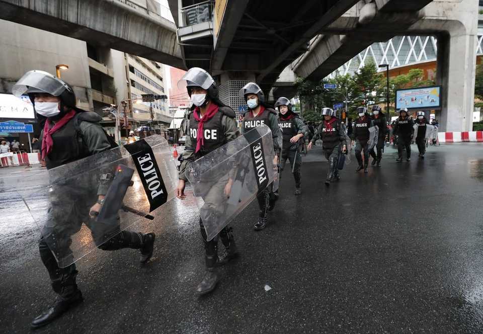 Thai police with riot shields take position in a business district where anti-government protesters said they will meet in Bangkok, Thailand, Friday, Oct. 16, 2020.