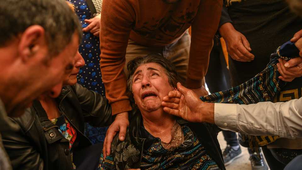 Relatives of Royal Sahnazarov, his wife Zuleyha Sahnazarova and their daughter Medine Sahnazorava, who were killed when a rocket hit their home, mourn during their funeral in the city of Ganja, Azerbaijan, on October 17, 2020