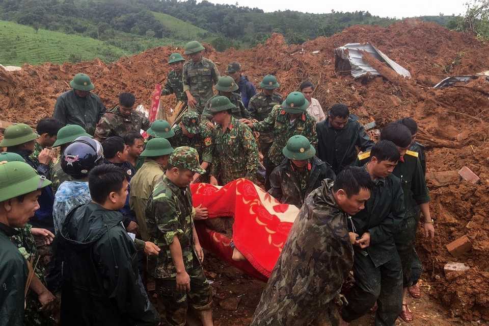 Military personnel carrying a body recovered from the site of a landslide in central Vietnam’s Quang Tri province, October 18, 2020.